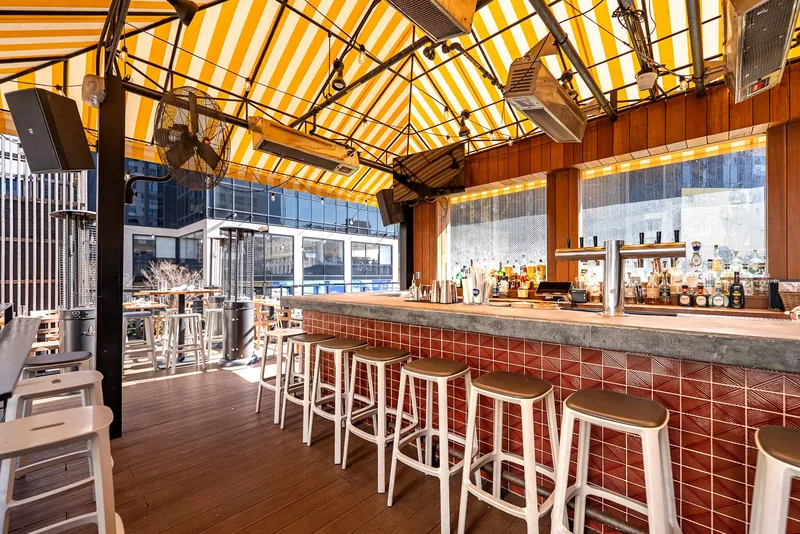 Rooftop bar with yellow sun shade at Avenida near Madison Square Garden